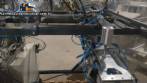 Pick and place product feeder for flowpack transfer cartoning machine