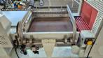 L-shaped packaging sealer with semi-automatic shrink tunnel.