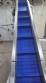 Inova Industrial inclined stainless steel conveyor belt with cleats.