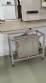 Label applicator machine with steam-operated shrink tunnel for sleeves.