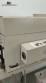 Label applicator machine with steam-operated shrink tunnel for sleeves.