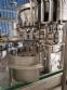 Zegla rotary filling machine with rinser and three-block capping system.